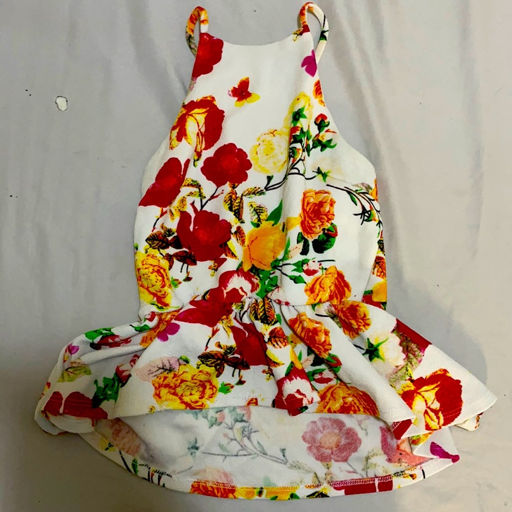 This is a halter top crop top shirt.open back with a cross look. White, floral